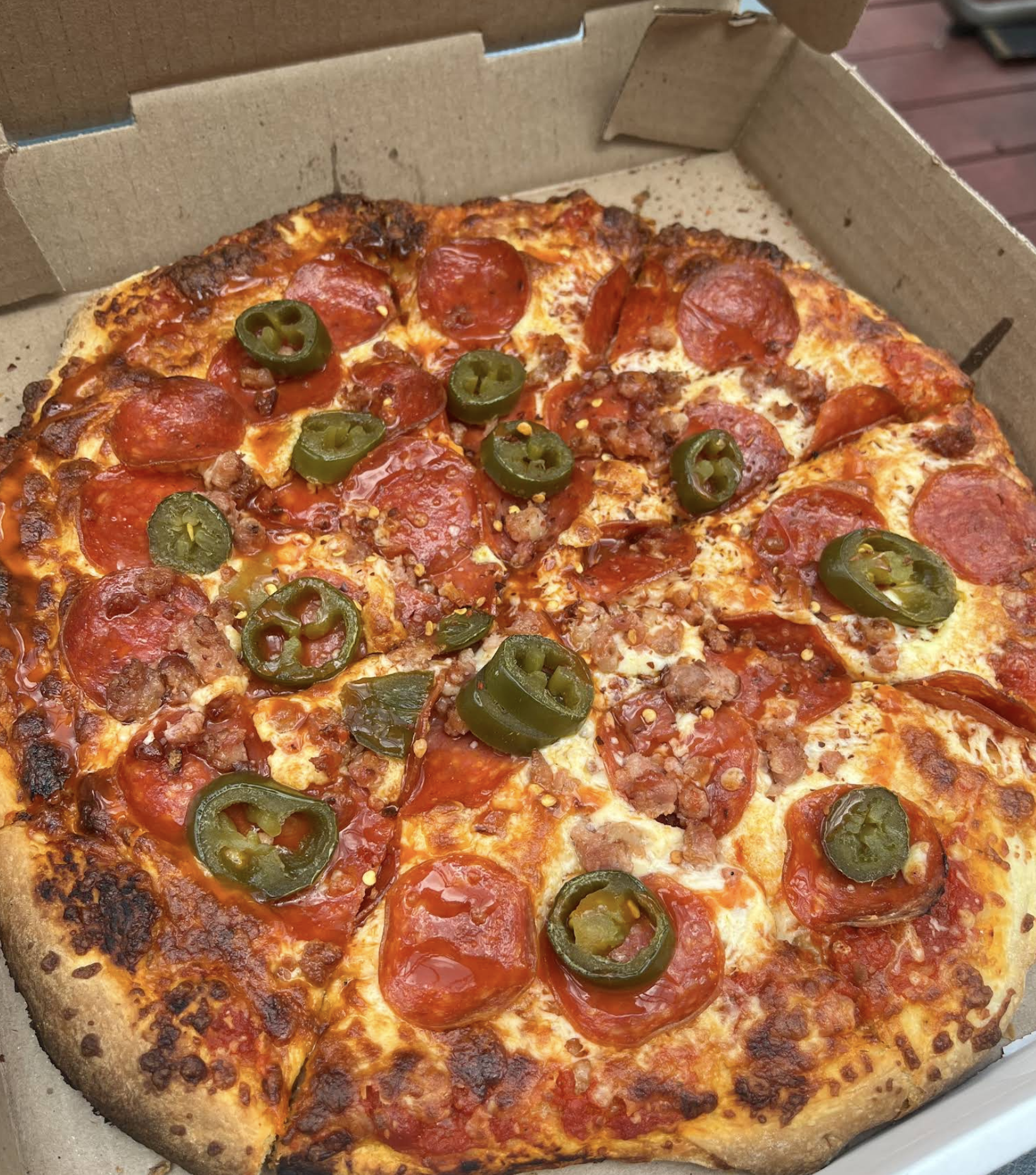 A loaded pizza featuring pepperoni, sausage, green peppers and jalapeños for a spicy kick.